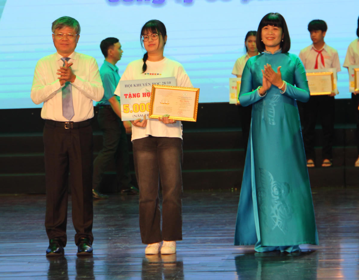 Lãnh đạo VRG và đại diện Tổng Liên đoàn Lao động Việt Nam trao thưởng cho các em. Ảnh: Q.Định.