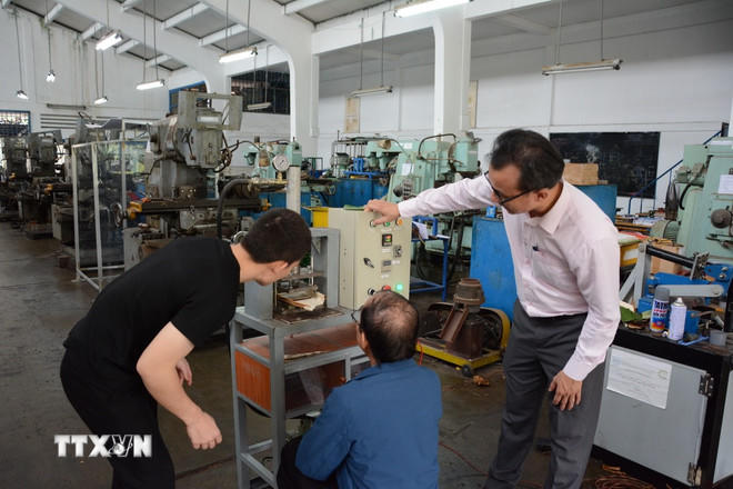 Giảng viên trường Đại học Sư phạm Kỹ thuật-Đại học Đà Nẵng hướng dẫn sinh viên chế tạo sản phẩm khoa học. (Ảnh: Văn Dũng/TTXVN).