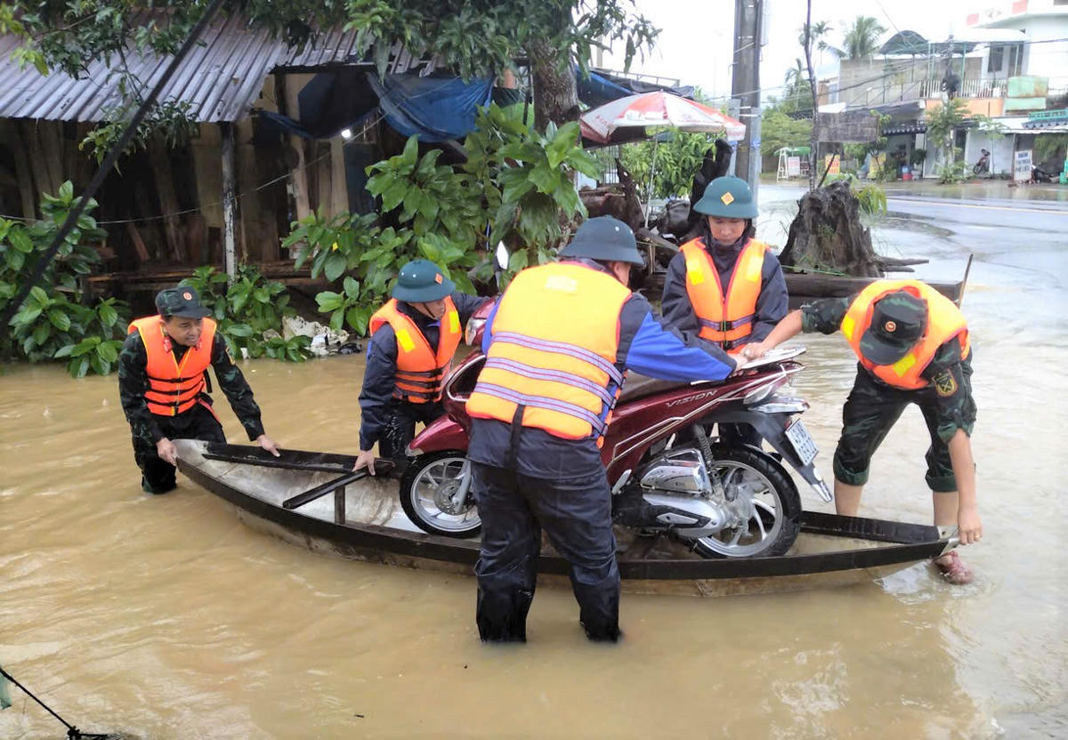 Lực lượng chức năng di dời tài sản của người dân ở vùng ngập nước. Ảnh: CV.