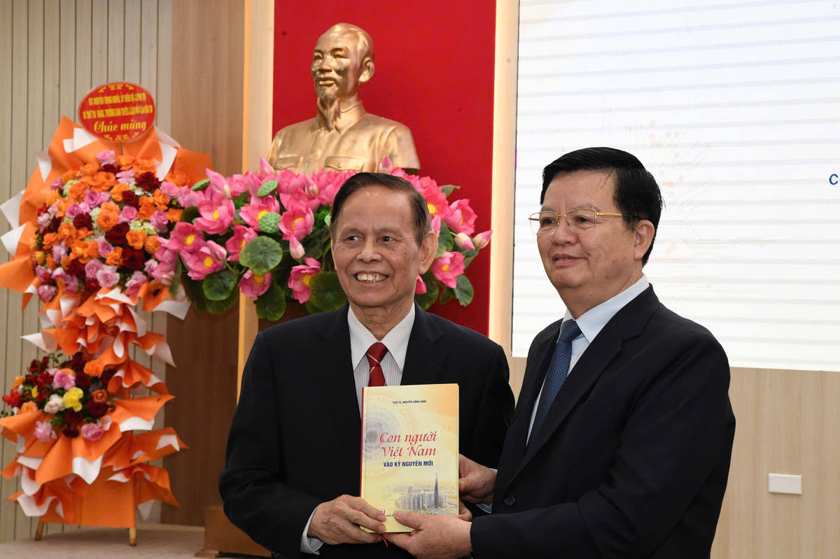 PGS.TS. Nhà báo Nguyễn Hồng Vinh tặng Phó Thủ tướng Chính phủ Mai Văn Chính cuốn sách “Con người Việt Nam vào kỷ nguyên mới" trong lễ ra mắt. Ảnh: Phạm Sỹ.