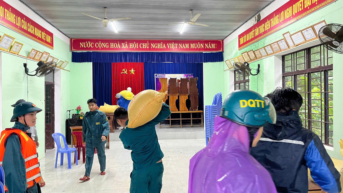 Di chuyển tài sản của người dân đến nơi cao ráo. Ảnh: Cẩm Vân.