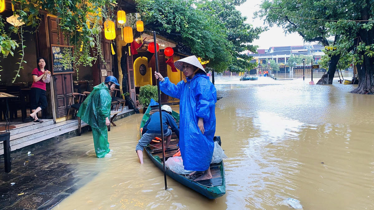 Người dân phường Hội An dùng ghe để di chuyển đoạn đường ngập nước sâu. Ảnh: T. Thành.