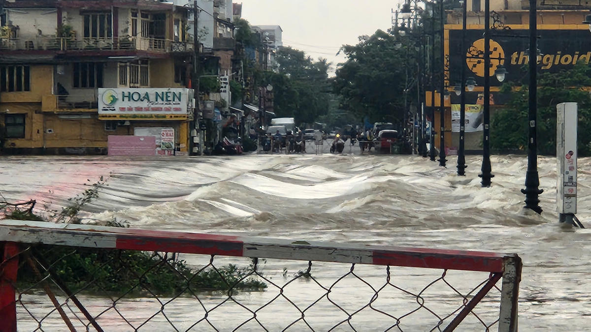 Mưa lớn trong nhiều giờ, nước sông dâng cao tràn qua Đập Đá, lực lượng chức năng tiến hành rào chắn không cho người và phương tiên qua lại để đảm bảo an toàn. Ảnh: N.Q.