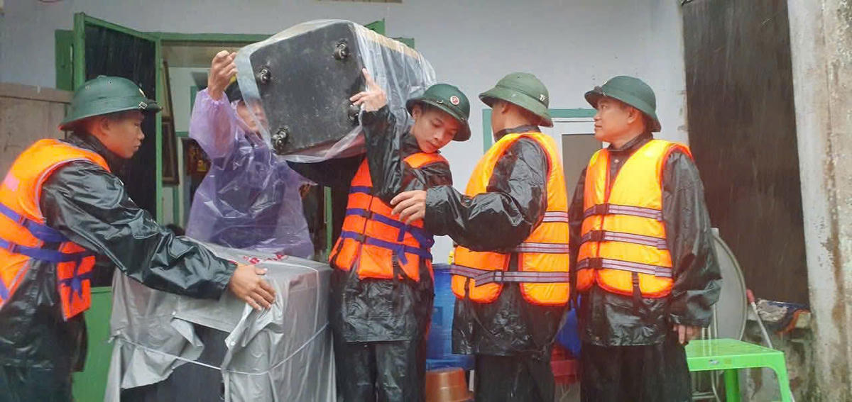 Cán bộ chiến sĩ Kho 55 hỗ trợ người dân di dời đồ đạc. Ảnh: Quang Hùng.&nbsp;