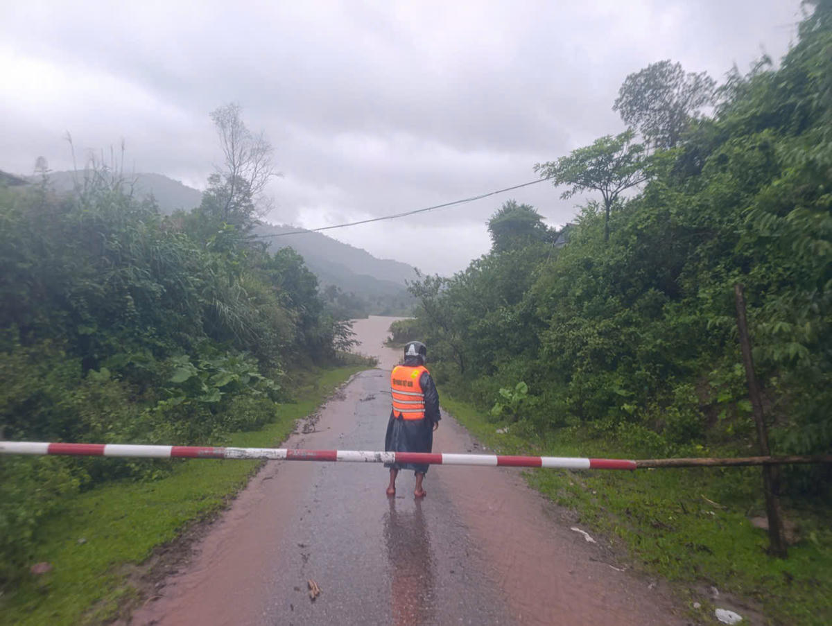 Lực lượng chức năng lập chốt chặn, tạm thời không cho người và phương tiện qua những nơi bị ngập nước. Ảnh: BP.