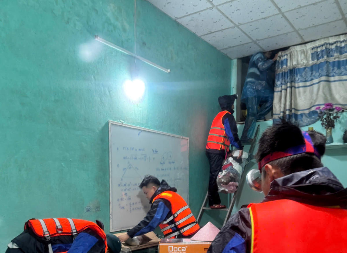 Lực lượng chức năng đưa đồ lên vị trí cao giúp người dân xã Quế Phước. Ảnh: CV.