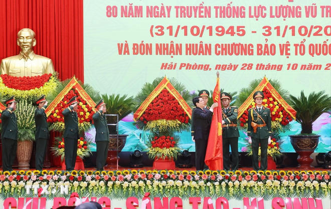 Chủ tịch nước Lương Cường gắn Huân chương Bảo vệ Tổ quốc hạng Nhất lên Quân kỳ Quyết thắng của Quân khu 3. (Ảnh: Lâm Khánh/TTXVN)