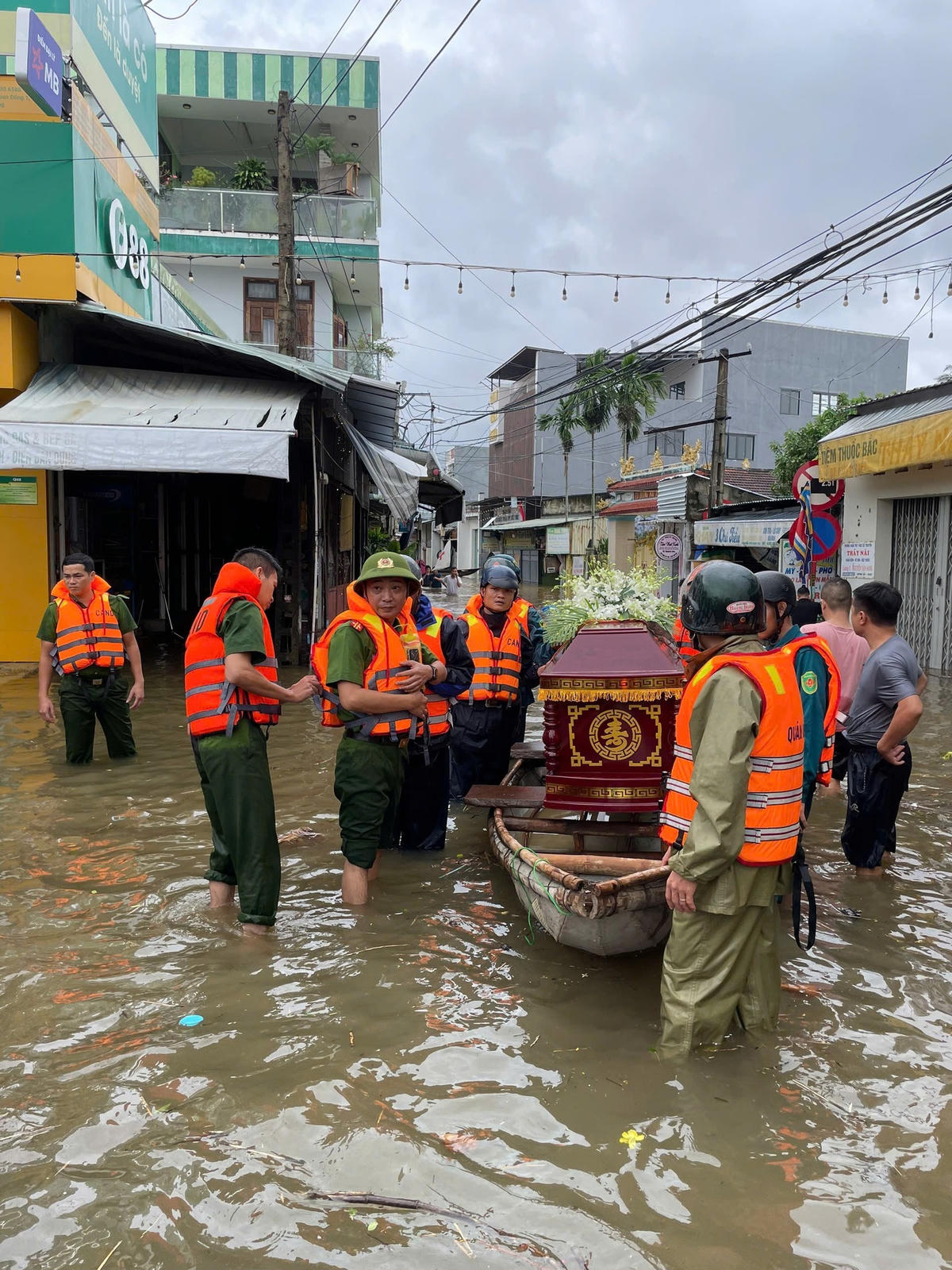 Công an xã Hòa Vang, TP Đà Nẵng phối hợp với lực lượng Cảnh sát đặc nhiệm Bộ Công an và bà con dân cư thôn Tuý Loan Đông 1 đã ngâm mình trong nước lũ đưa linh cữu cụ bà Lâm Thị Đối, thọ 93 tuổi về nơi an nghỉ cuối cùng.&nbsp;Ảnh: Nguyễn Tú.. 