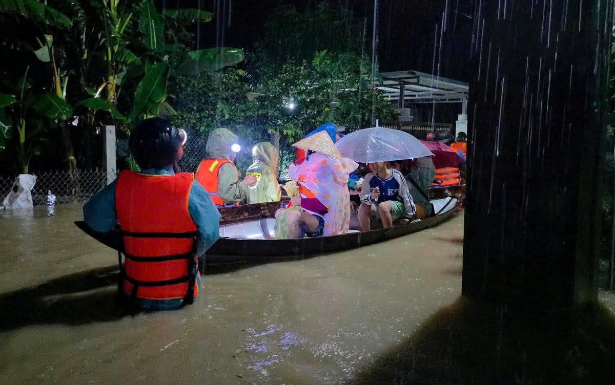 Lực lượng chức năng sử dụng ghe di chuyển người dân ra khỏi vùng ngập lụt sâu. Ảnh: C.Đại.