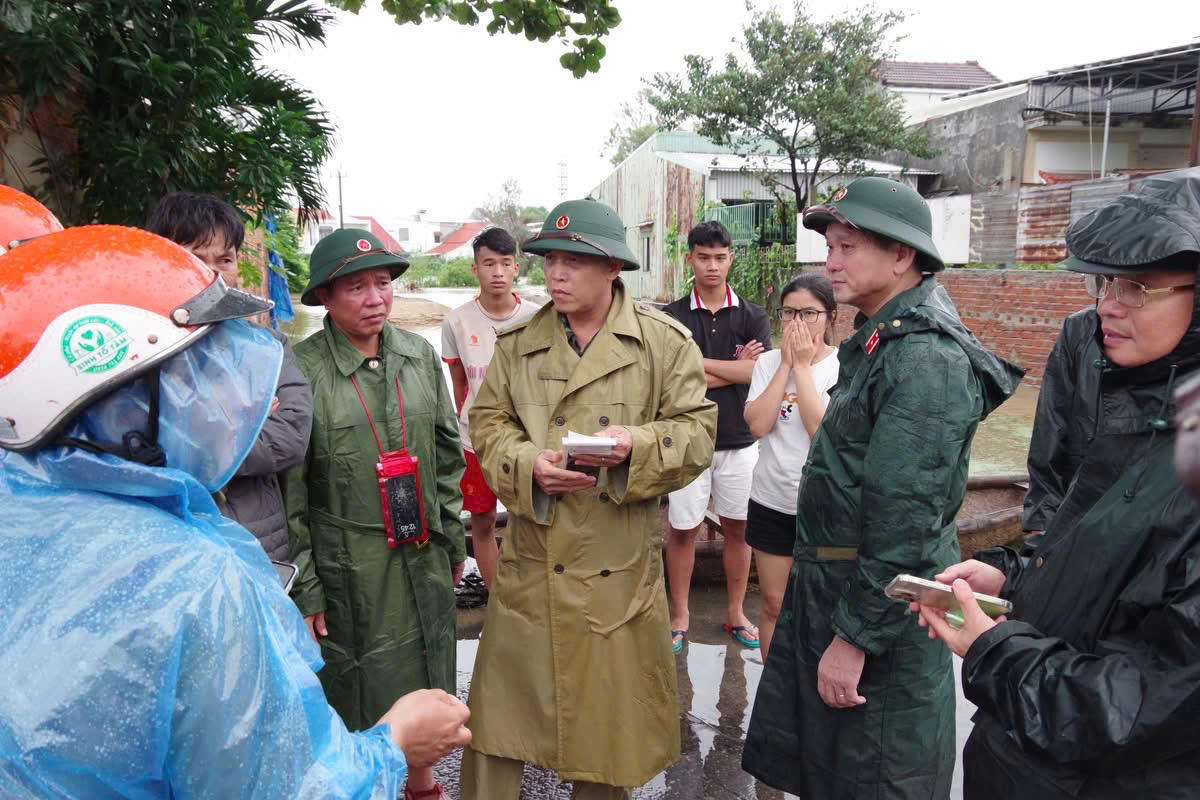 Đại tá Trần Hữu Ích, (ở giữa) Chỉ huy trưởng Bộ Chỉ huy Quân sự TP Đà Nẵng nghe báo cáo về công tác di dời dân ở vùng ngập lụt. Ảnh: CV.