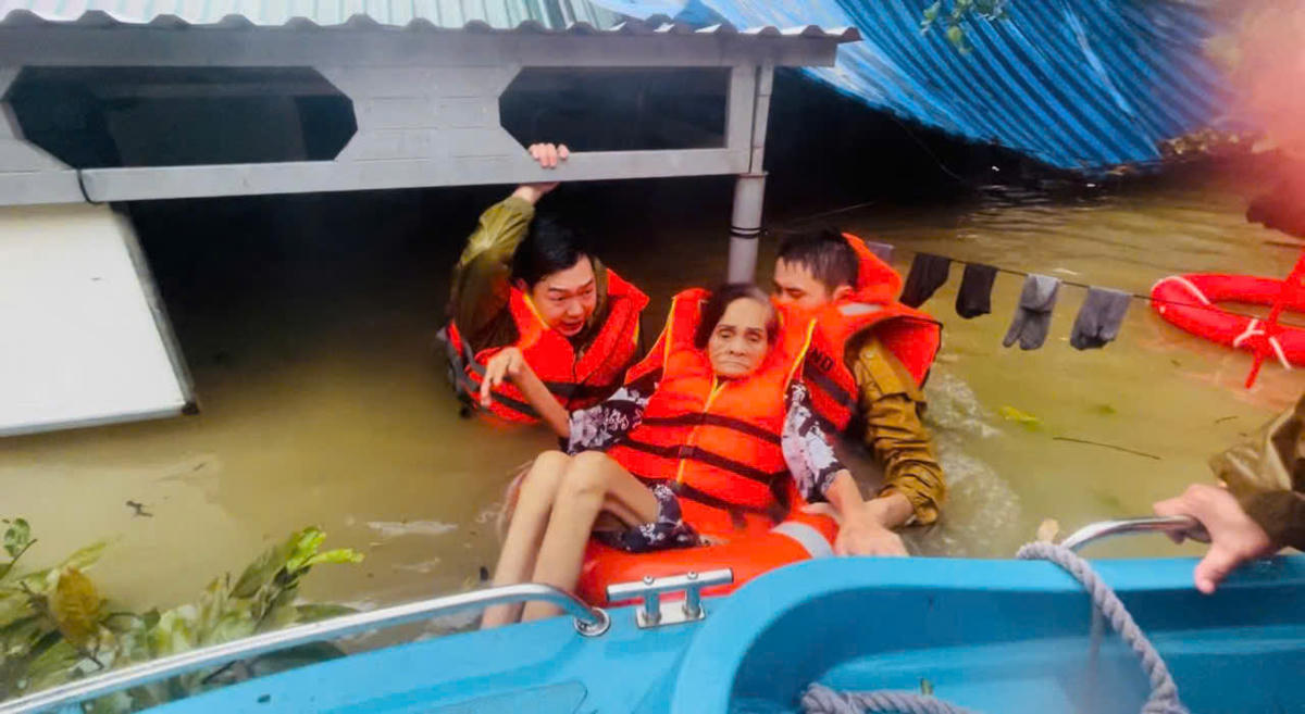 Lực lượng Công an hỗ trợ người dân vùng bị ngập sâu, cô lập đến nơi an toàn. Ảnh; CACC.