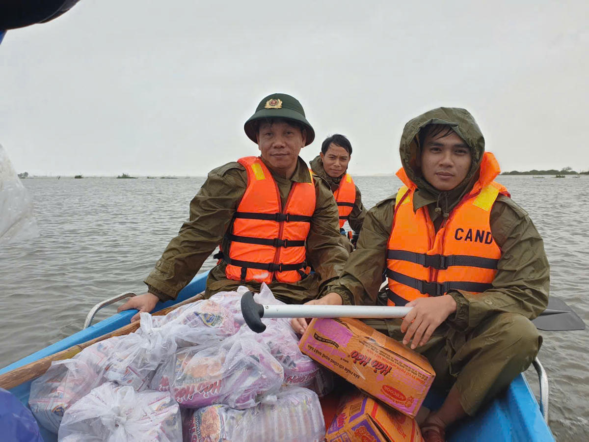 Công an xã Phú Hồ mang mì ăn liền đến cho người dân vùng bị ngập lụt.