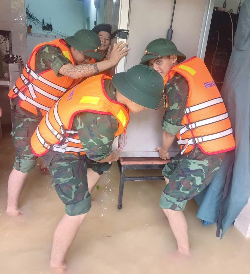 Lực lượng dân quân giúp người dân Hội An sơ tán đồ đạc. Ảnh: T.Thành.