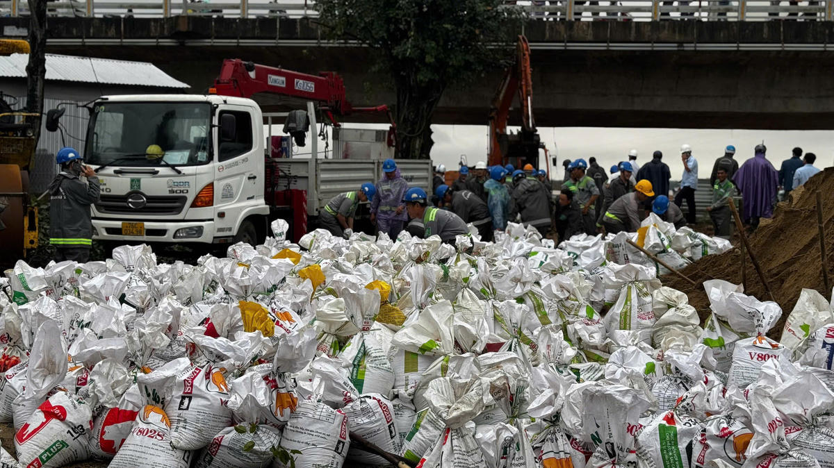 Hàng nghìn bao cát được đưa vào bịt miệng cống.Ảnh: CV.