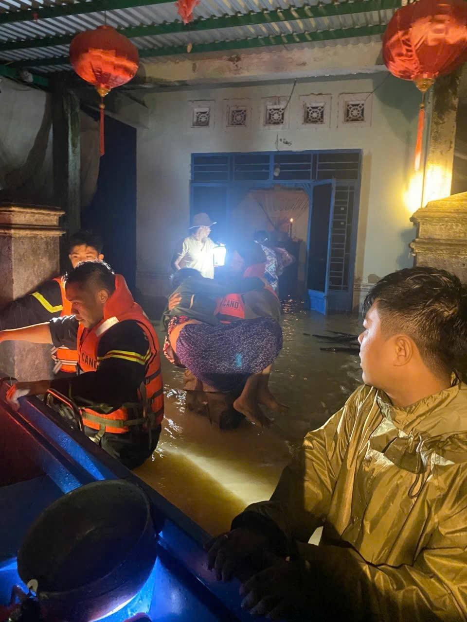 Công an xã Hòa Vang và lực lượng cảnh sát PCCC cứu cụ bà bị cô lập trong nhà ngập nước. Ảnh: Công an xã.