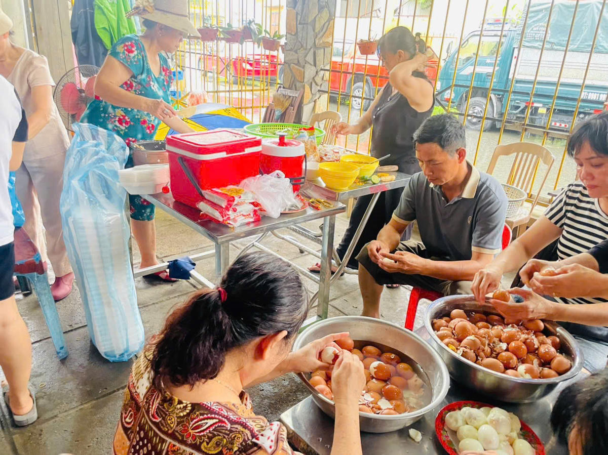 Hội Liên hiệp Phụ nữ phường Điện Bàn Bắc cùng người dân chuẩn bị suất ăn gửi bệnh nhân vùng lũ. Ảnh: Nguyễn Tú.