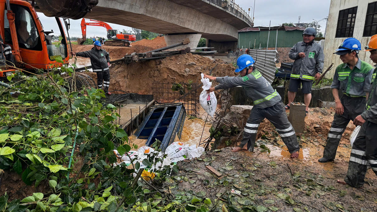 Công nhân đô thi đang đưa bao cát gia cố bịt miếng cống, gần bờ sông Trà Khúc. Ảnh: CV.