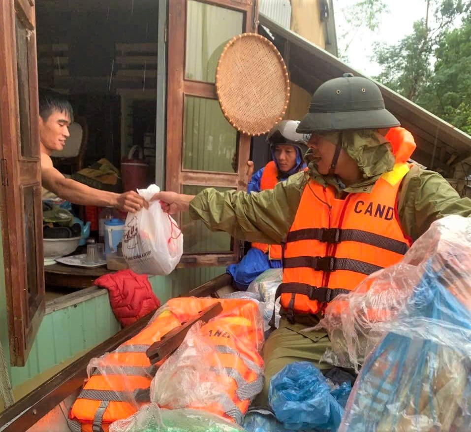 Lực lượng Công an phường Điện Bàn Bắc phát đưa thực phẩm cho người dân vùng lũ. Ảnh: CV.