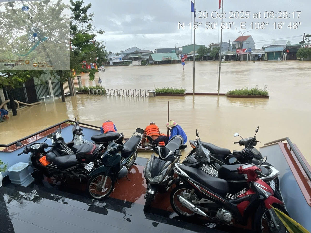 Đội Quản lý điện Duy Xuyên nhận giữ xe máy ở vị trí cao ráo, không bị ngập nước cho người dân. Ảnh: Đức Lâm.