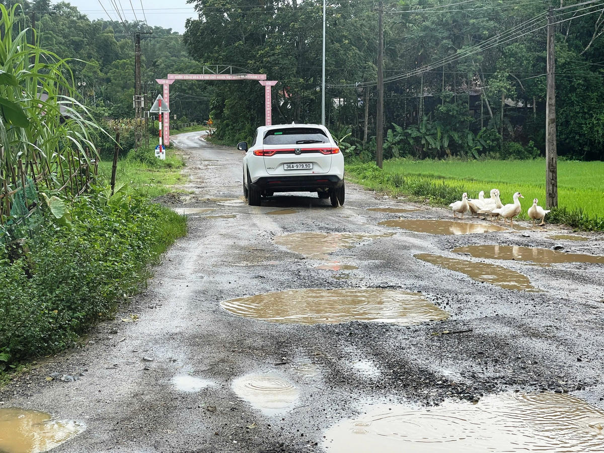 Xe ô tô 5 chỗ vất vả vượt qua các ổ trâu, ổ voi trên mặt đường. Ảnh: Nguyễn Chung.