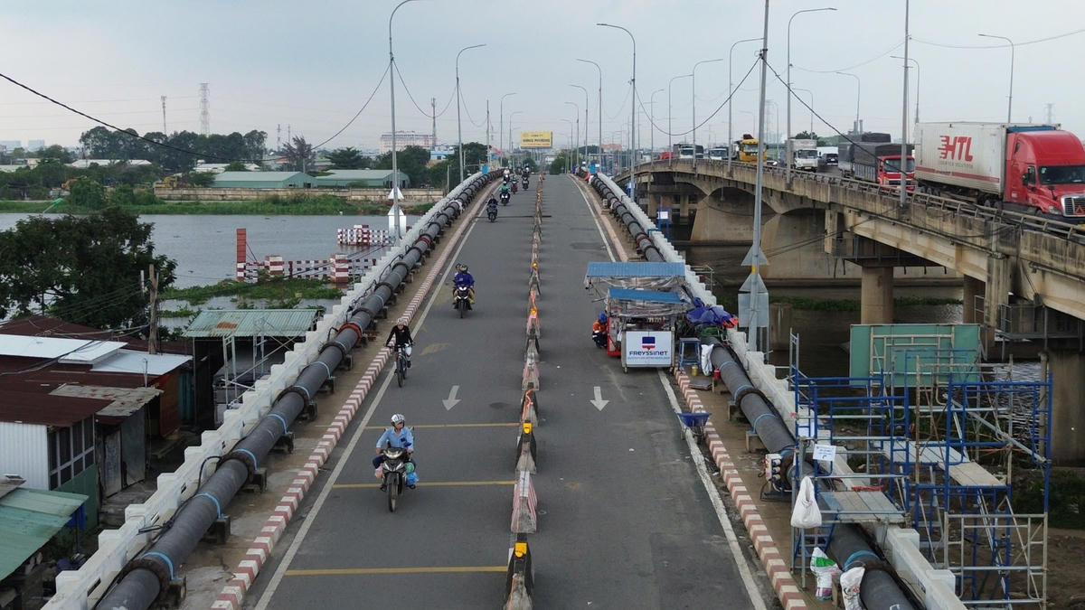 Mặc dù các kỹ sư thi công nhưng các phương tiện xe gắn máy, xe đạp, người đi bộ... vẫn được phép qua cầu. Riêng xe ô tô được phân luồng trên cầu Bình Phước 2 nằm song song. Ảnh: Đ.Xá.