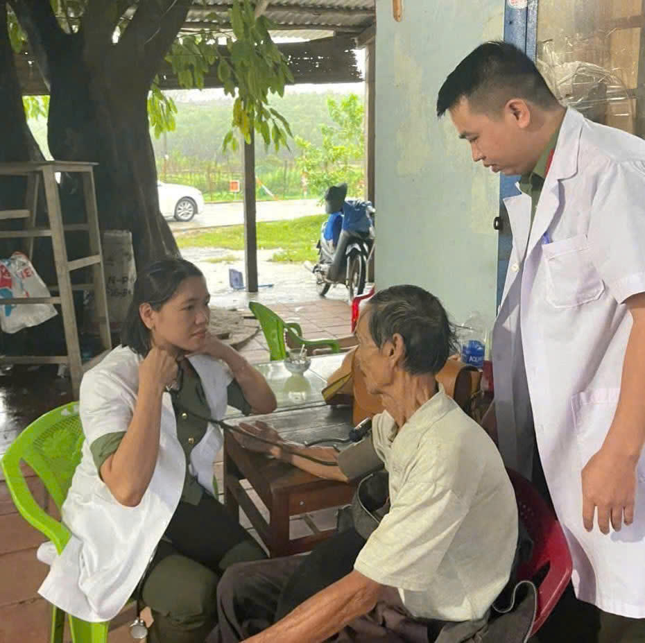 Một trong những chiến sĩ "áo trắng” của Bệnh xá Phòng Hậu cần – Công an TP Đà Nẵng đang khám bệnh cho người dân vùng cô lập vì lũ. Anh: TấnThành.