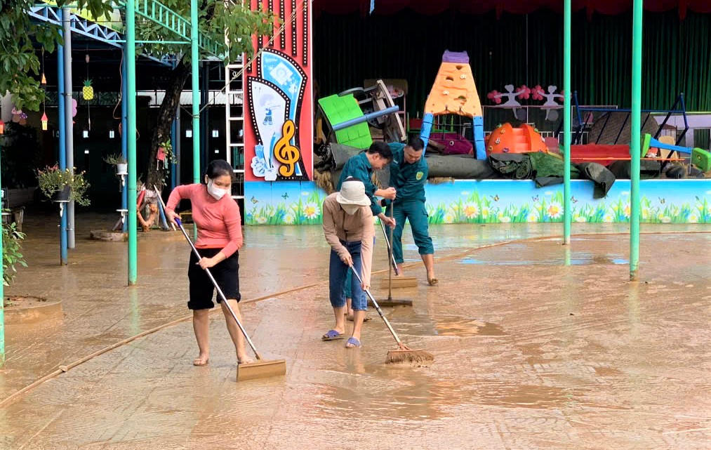 Các cô giáo của Trường mầm non Đại An đang dọn bùn non bám dày trong khuôn viên. Ảnh: CV.