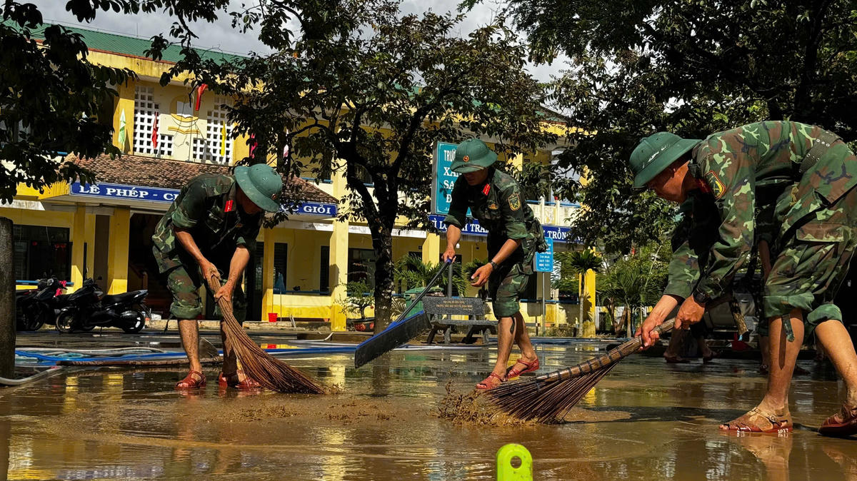 Chiến sĩ Trung đoàn Bộ binh 887 đang quét dọn vệ sinh sân trường học tại xã Bình Minh để học sinh đi học trở lại. Ảnh: CV.. 