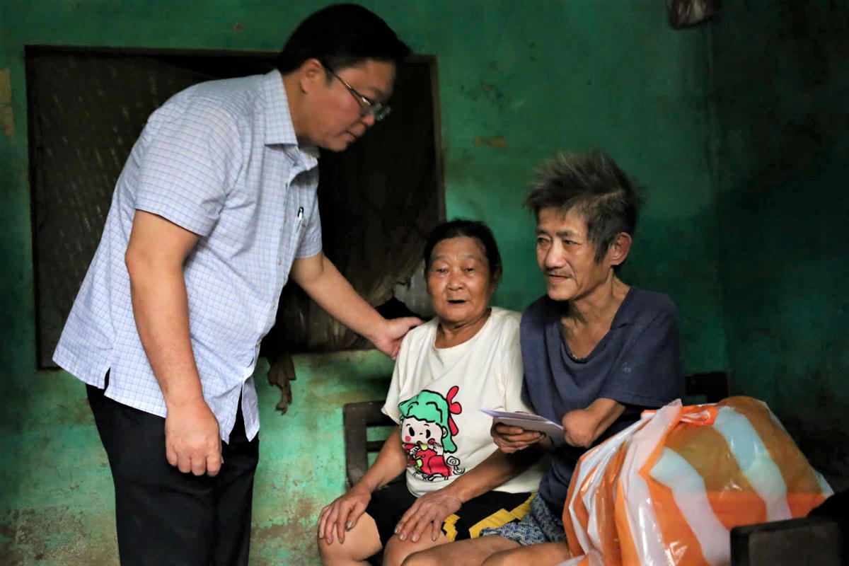 Chủ tịch Ủy ban Mặt trận Tổ quốc Việt Nam TP Đà Nẵng Lê Trí Thanh thăm, tặng quà hộ dân có người già, đau ốm trong vùng lũ thôn Kỳ Bì. Ảnh: Chí Đại.