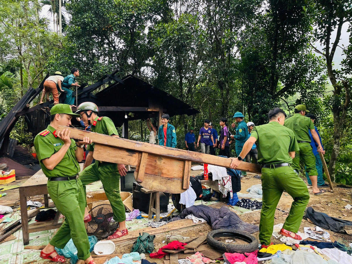 Các chiến sĩ công an góp sức để tháo dỡ, di dời nhà. Ảnh: Dương Ngân.