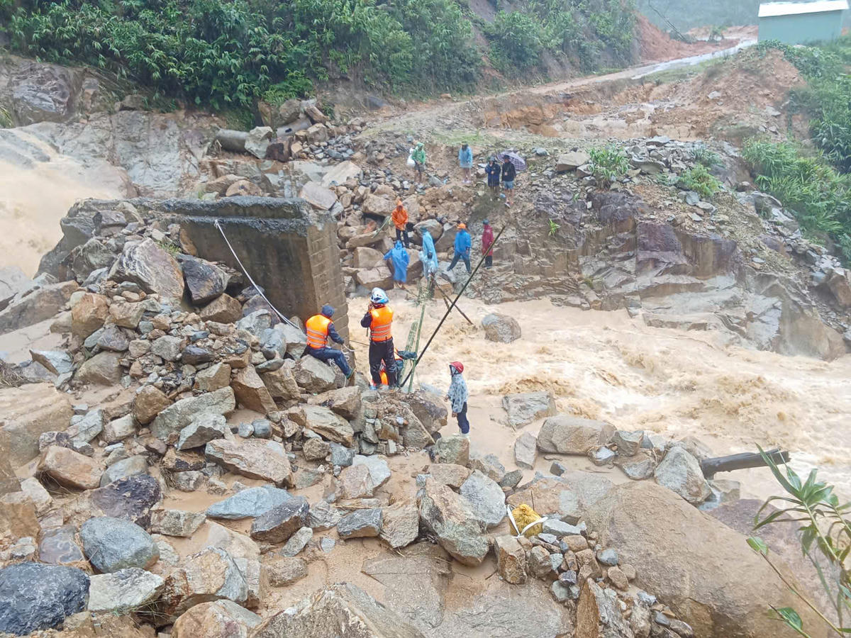 Lực lượng chức năng làm cầu tre tạm cho chị Khuyên đi qua. Ảnh: CV.