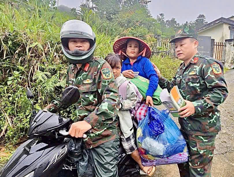 Lực lượng chức năng hỗ trợ người dân xã Tây Trà Bồng đi sơ tán. Ảnh: CV.