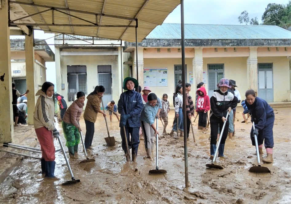 Lớp bùn đất non bám dày đặc trên sân Trường TT-THCS Đăk Man sau trận lũ. Ảnh: Chí Đại.