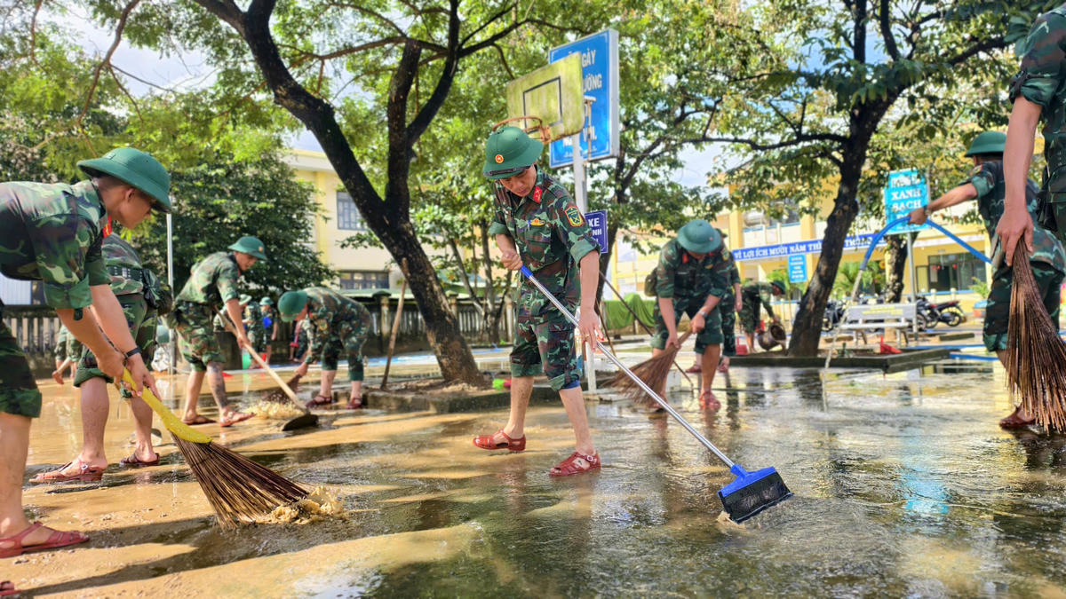 Lực lượng cán bộ, chiến sĩ dọn vệ sinh tại trường học ở xã Bình Minh sau lũ. Ảnh: Chí Đại.