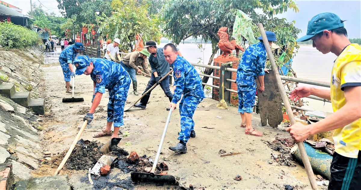 Cán bộ, chiến sĩ Bộ Tư lệnh Vùng Cảnh sát biển 2 dọn dẹp bùn đất trên địa bàn phường Hội An Tây. Ảnh: CV.