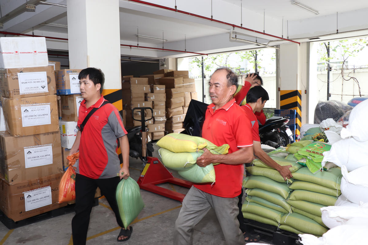Các nhân viên tình nguyện khẩn trương bốc xếp hàng cứu trợ đồng bào tại Huế và Đà Nẵng. Ảnh: AH.