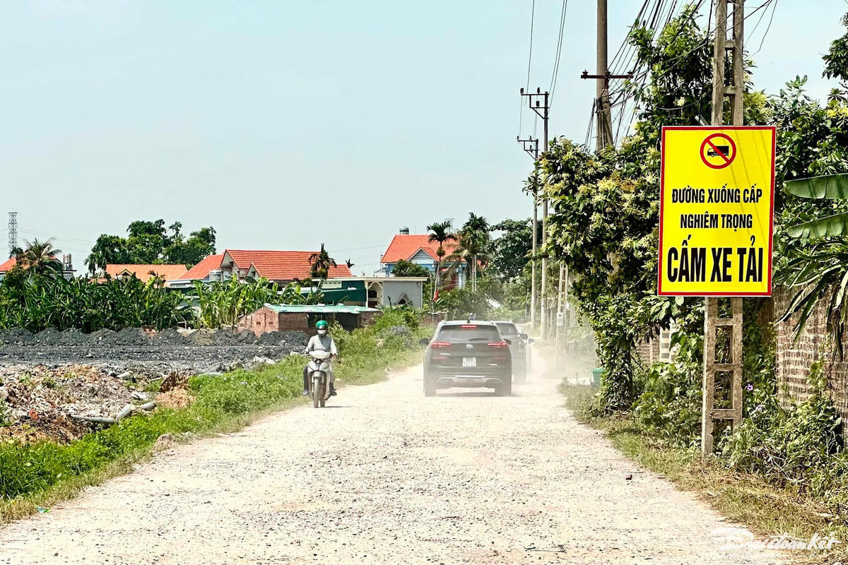 Đầu đường Vũ Tướng (đoạn qua khu phố Động Linh) gắn biển cảnh báo "Đường xuống cấp nghiêm trọng - Cấm xe tải". Ô tô đi qua con đường này cuốn theo bụi bay mù mịt. Ảnh: Ngọc Anh.