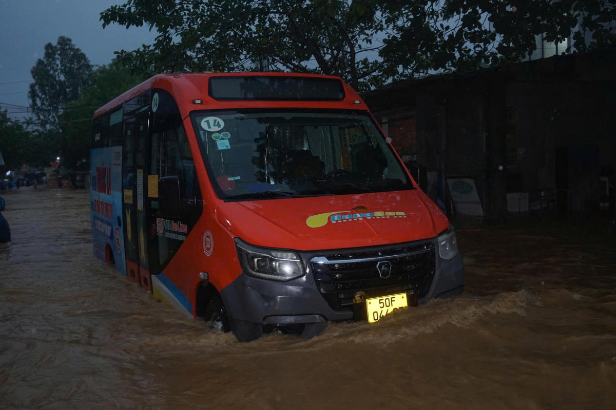 Xe buýt chạy tuyến cố định vượt dòng nước ngập. Ảnh: Nguyễn Tú.
