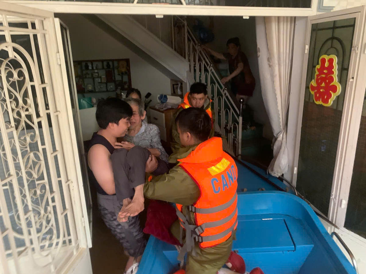 Lực lượng chức năng căng mình hỗ trợ di dời người dân ngập lụt đến nơi an toàn. Ảnh: CACC.