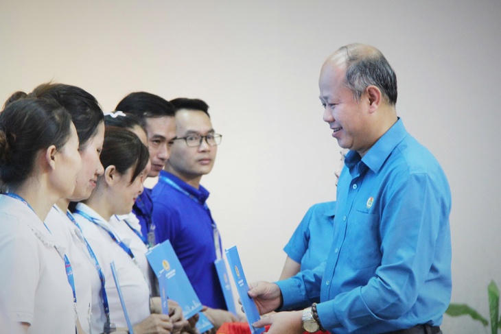 Ông Lê Văn Đại, Phó chủ tịch thường trực Liên đoàn Lao động thành phố Đà Nẵng, trao hỗ trợ cho công nhân chịu thiệt hại do bão lũ - Ảnh: V.T.