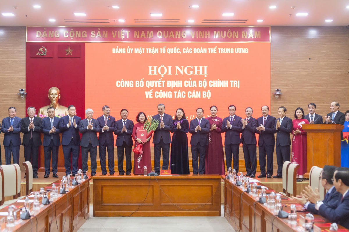 Tổng Bí thư Tô Lâm và các đại biểu tặng hoa chúc mừng bà Bùi Thị Minh Hoài. Ảnh: Quang Vinh.