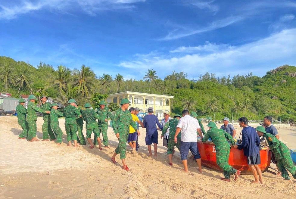 Chiến sĩ Đồn Biên phòng Nhơn Châu, tỉnh Gia Lai giúp dân di dời thuyền, thúng đến vị trí an toàn. Ảnh: Th. Loan.&nbsp;