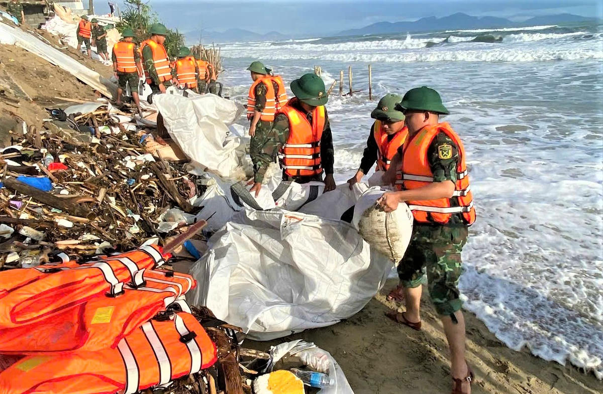 Hàng trăm bao cát được bộ đội vận chuyển kè sạt lở bờ biển An Bàng. Ảnh: CV.
