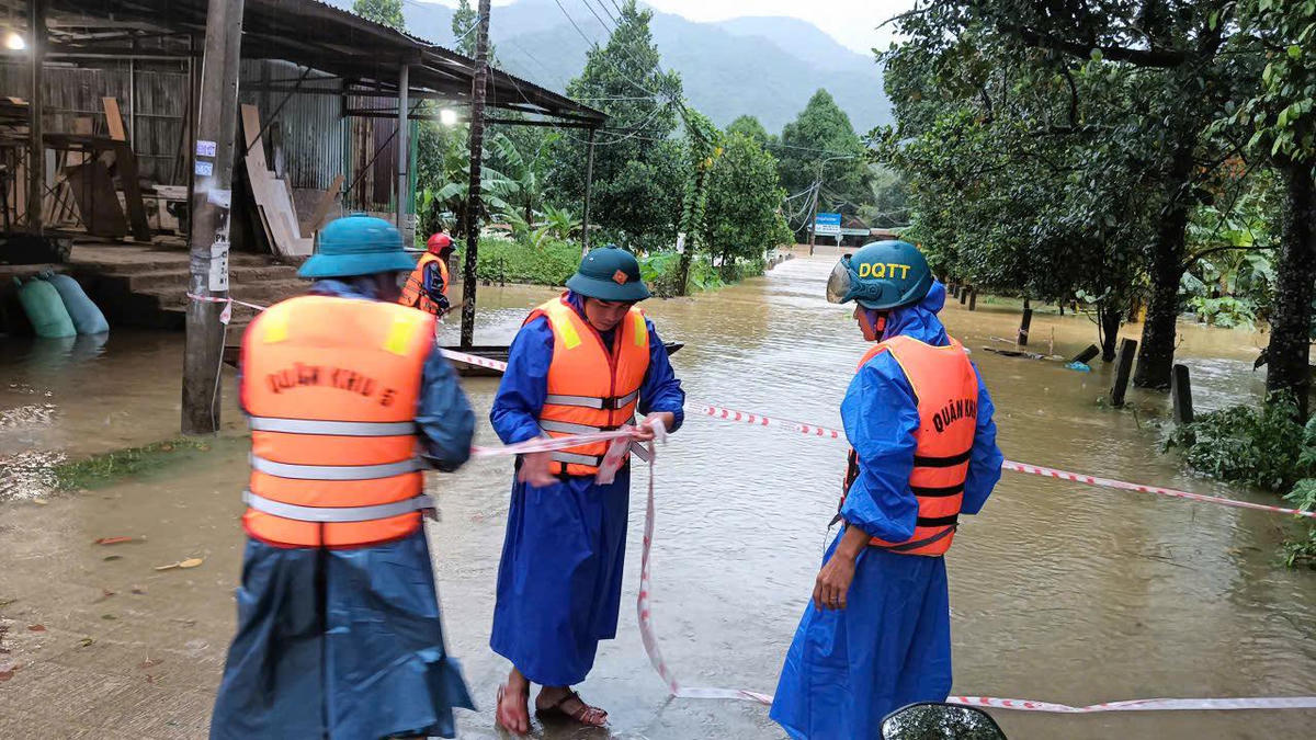 Lực lượng cán bộ, chiến sĩ Ban chỉ huy Quân sự phường Hải Vân căng dây cảnh báo các tuyến đường ngập không thể lưu thông. Ảnh: Kim Hiếu.