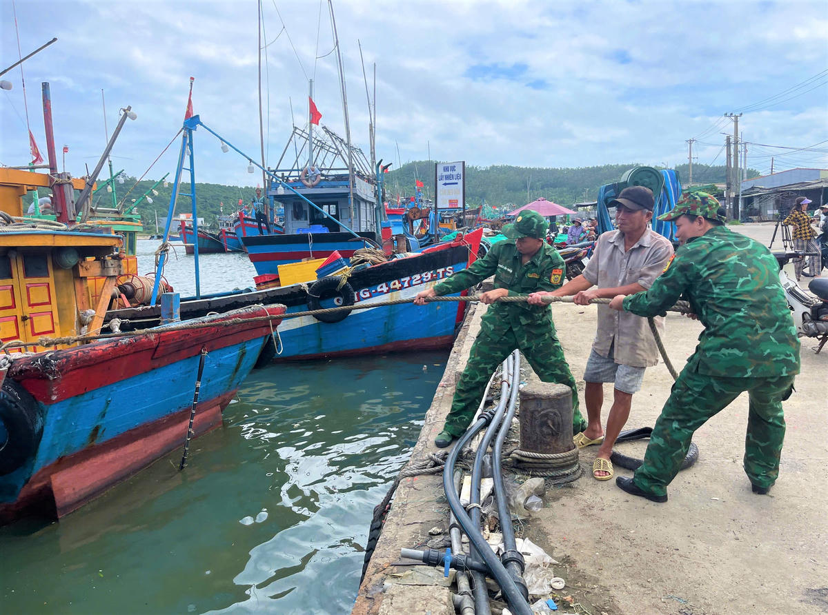 Lực lượng chức năng giúp ngư dân neo đậu tàu thuyền cố định tránh va đậm tàu khác tại cảng Sơn Tịnh. Ảnh: Ảnh: CV.