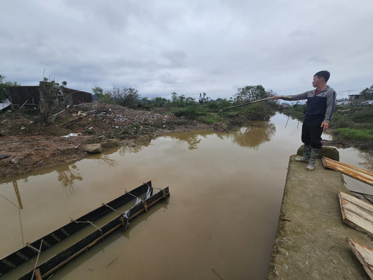 Anh Nguyễn Doãn Nghĩa chỉ cho phóng viên các khối bê tông vỡ ra từ mố cầu đang thi công. Ảnh: Quốc Thanh.