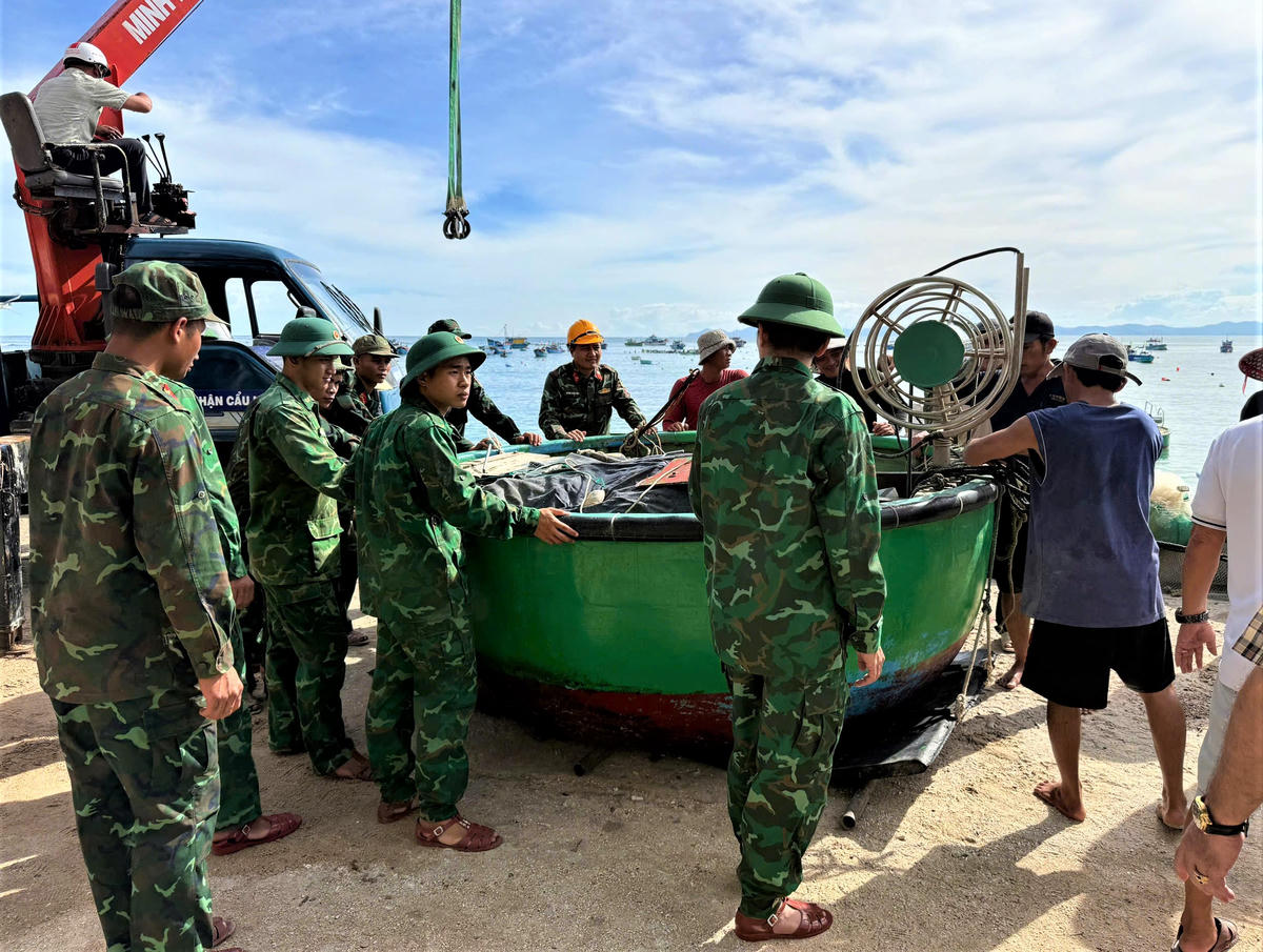 Lực lượng quân đội, biên phòng tỉnh Gia Lai giúp ngư dân di chuyển ghe thuyền lên bờ. Ảnh: T.Thành.