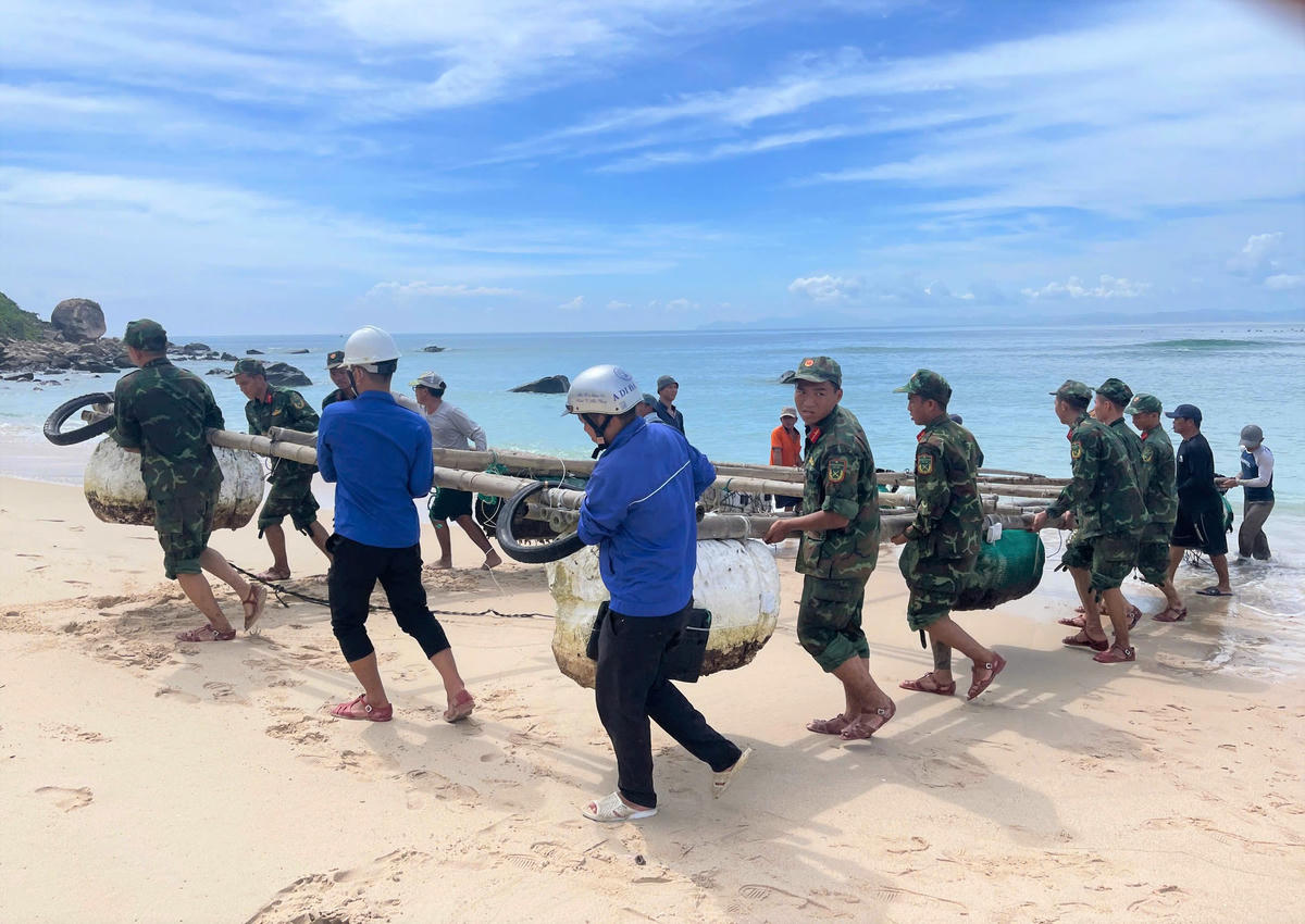 Lực lượng chức năng cùng người dân tỉnh Gia Lai đưa ghe thuyền lên bờ tránh bão số 13. Ảnh: Đ.Sang.