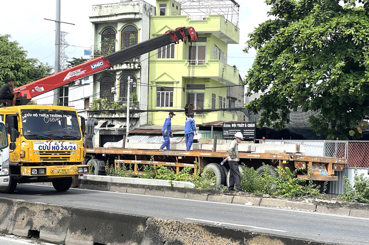 Nhà thầu thi công lắp rào chắn, tập kết vật liệu xây dựng trên Quốc lộ 1A. Ảnh: Đ.Xá.
