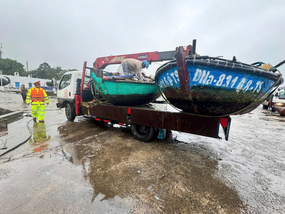 Lực lượng Công an cùng ngư dân đưa tàu thuyền lên bờ trú tránh bão số 13. Ảnh: CV.